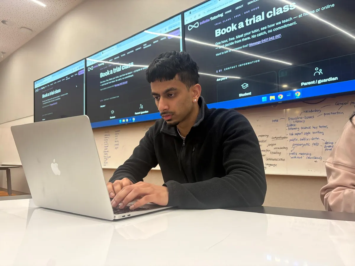 An Infinite Tutoring tutor working at a laptop