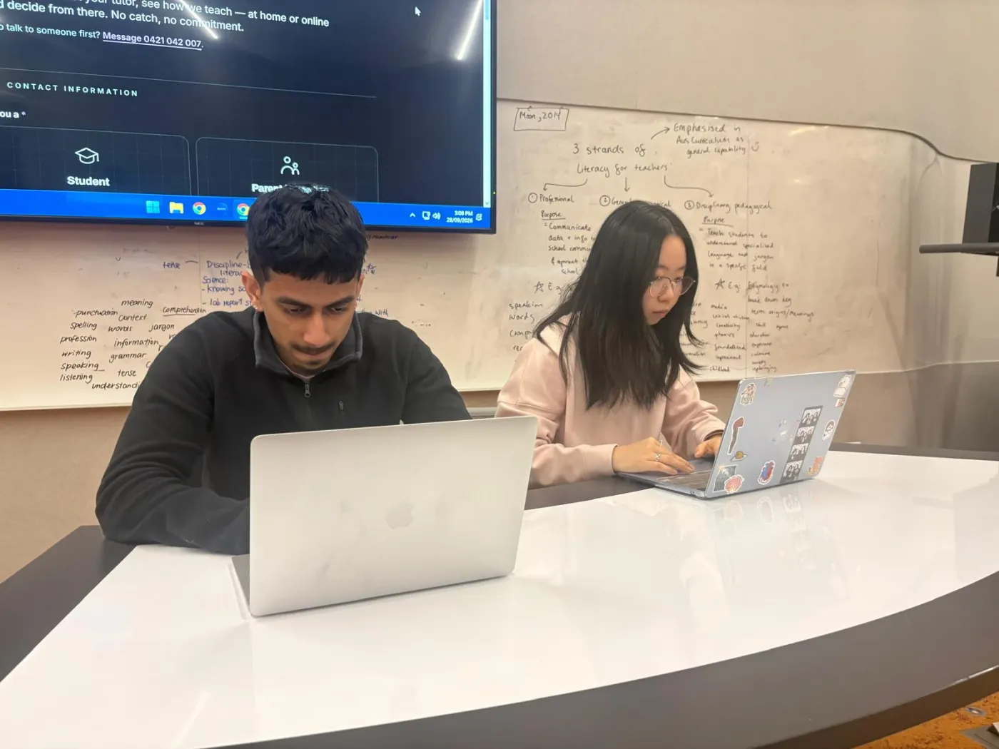 Two Infinite Tutoring tutors working at their laptops